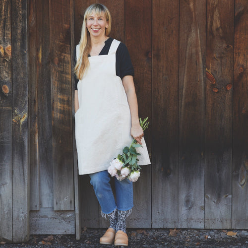 Our pure cotton, cross-back apron is both stylish and utilitarian, and designed to fit all body types. Featuring wide front pockets, it is ideal for working in the garden, kitchen, or studio. Each apron is soft-washed for added comfort. Azo-free dye.  Pure Cotton and hand sewn. Machine washable. One size fits most.