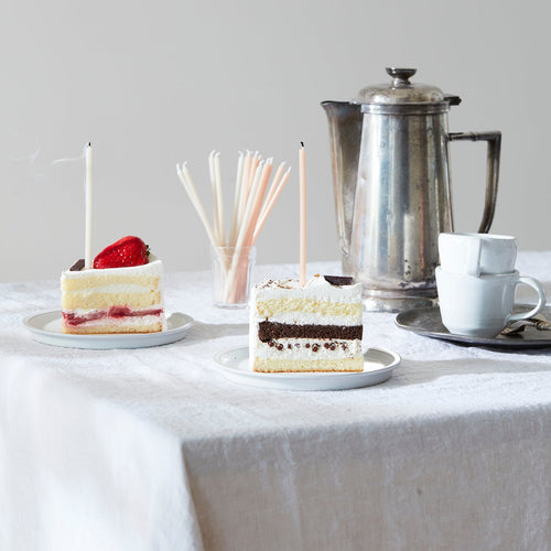 Floral Society wishing candles blown out on small pieces of cake, served with coffee. Skinny taper candle can be used as a meditation candle or birthday candle alike