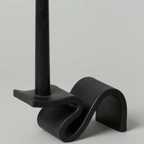 Black metal stand with curved design on a gray background