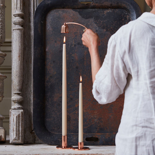 The copper candle snuffer is the perfect candle accessory and standalone accent for your shelf or table alongside the candles and holders in our collection. Inspired by vintage snuffers, our copper candle snuffer has a rotating movement allowing for easy maneuvering and access to hurricane lanterns, a mixed assortment of tapers, and tall overhead candles. Place the snuffer directly over the candle flame to extinguish while avoiding dripping and wax splatter. Handmade and solid copper.