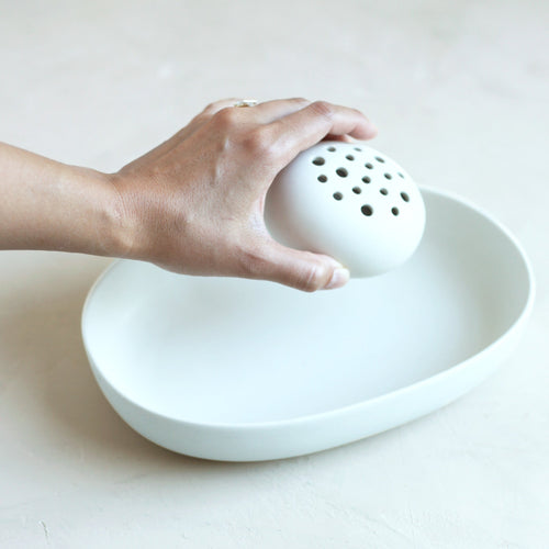 Our stand-alone ceramic frog is perfectly paired with the oval dish. It can also be used independently or with any open vessel of your choosing. The holes can be filled with water to display a minimal selection of flowers, or keep herbs fresh on your kitchen counter. When not in use, display it as a sculptural object.